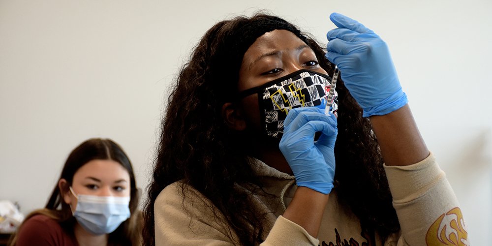 Melissa High School medical assisting student practices immunization administration
