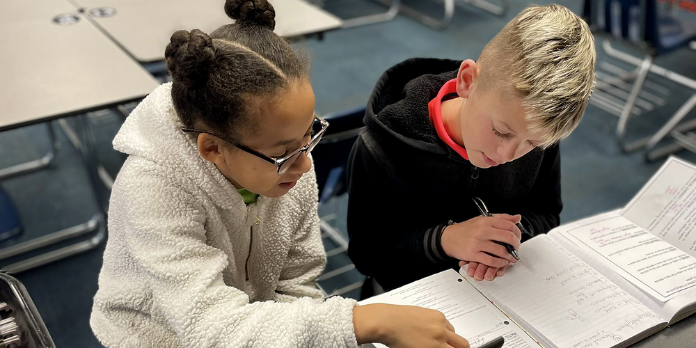 two middle school students work together on an assignment at school