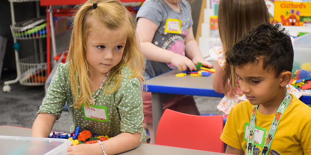 Pre-K students play with blocks at their table