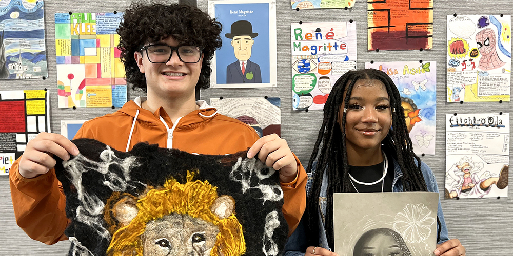 students Logan D'Amore and Madison Smith hold up their artwork
